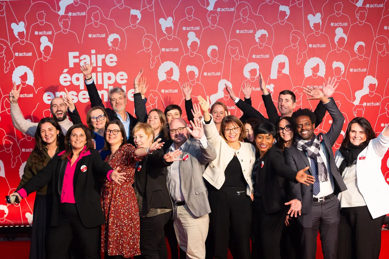 Une équipe de collaborateurs Actual tout sourire devant le slogan rouge « Faire équipe ensemble ».