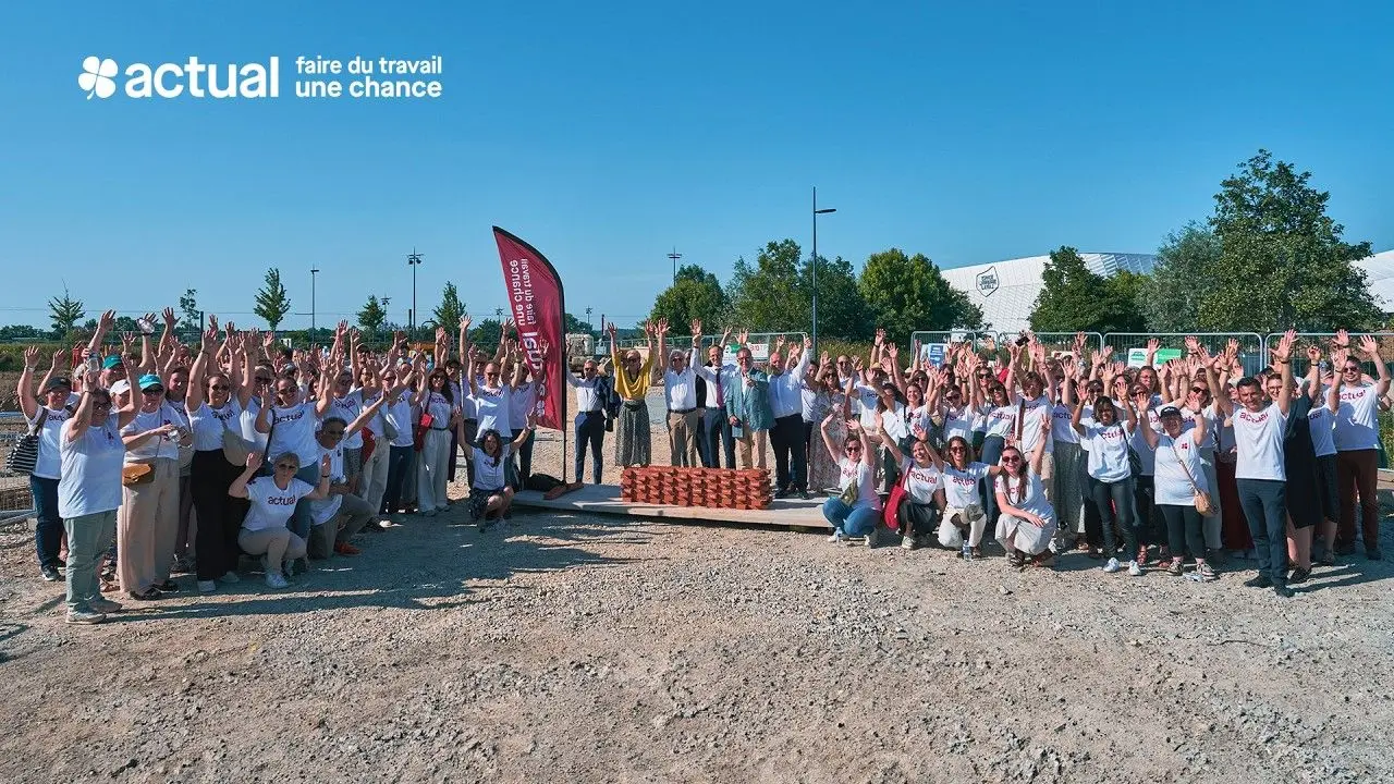 Collaborateurs d'Actual réunis les bras levés lors de la pose de la première pierre d'un chantier.