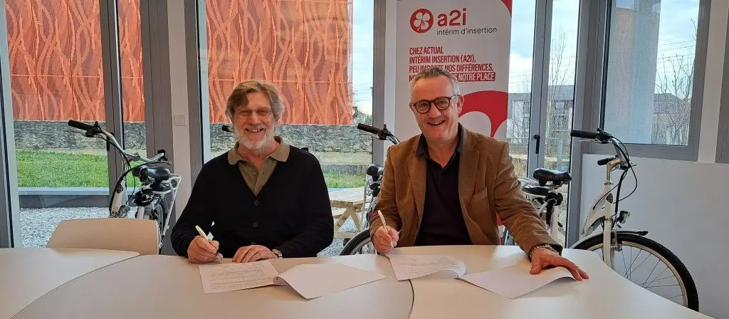Deux hommes assis signent le partenariat entre Ergos Actual Insertion et ETIC 53.