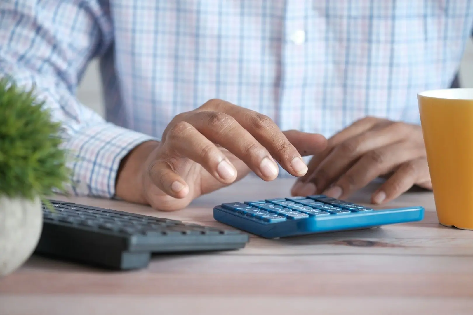 Une personne utilise une calculatrice pour calculer le coût d'un intérimaire.