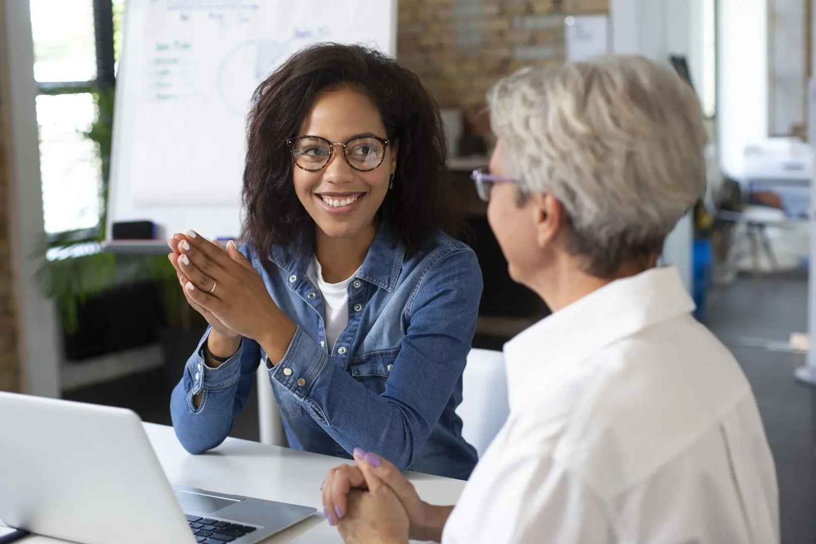 Une candidate souriante échange avec dynamisme lors d'un entretien de recrutement en entreprise.