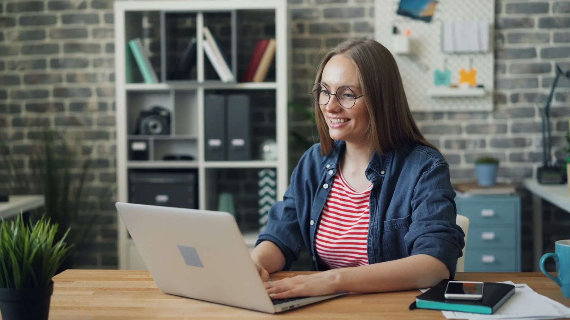 Une candidate souriante utilise son ordinateur portable pour un entretien professionnel en ligne.