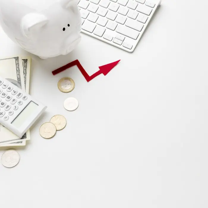 Une tirelire, une calculatrice, des pièces et une flèche rouge ascendante évoquant la gestion d'un crédit ou d'un budget.